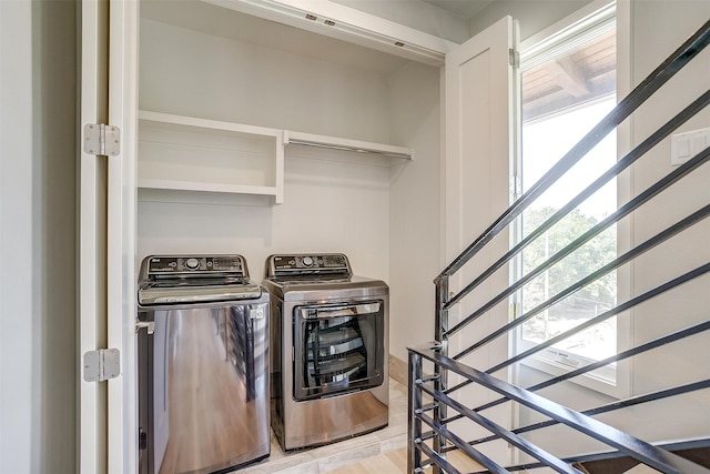 clothes washing area featuring independent washer and dryer, light wood-type flooring, and a healthy amount of sunlight