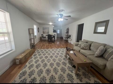 living room featuring ceiling fan, wood finished floors, and baseboards