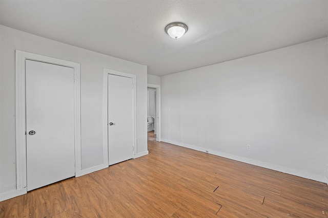 unfurnished bedroom featuring light wood-type flooring and a textured ceiling