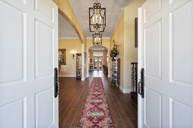 entrance foyer featuring crown molding, dark hardwood / wood-style flooring, and a chandelier