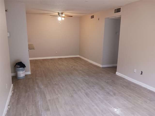 empty room with ceiling fan and light hardwood / wood-style floors