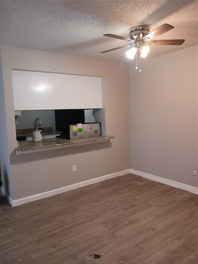 spare room featuring ceiling fan, dark hardwood / wood-style floors, and a textured ceiling