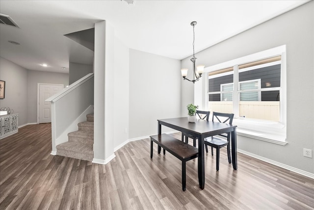 dining room featuring hardwood / wood-style floors and an inviting chandelier