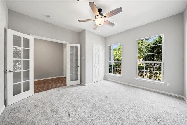 empty room with french doors, ceiling fan, and carpet flooring