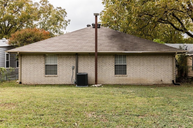 rear view of property featuring central AC unit and a yard