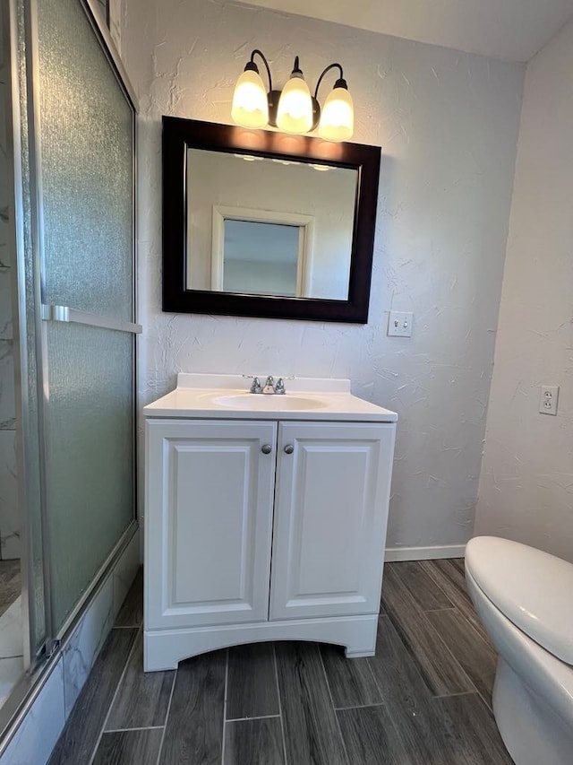 bathroom featuring toilet, vanity, and hardwood / wood-style flooring