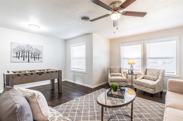 interior space with ceiling fan, a wealth of natural light, and dark hardwood / wood-style floors