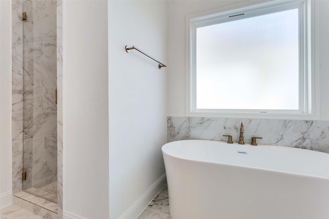 full bath featuring marble finish floor, tiled shower, a soaking tub, and baseboards