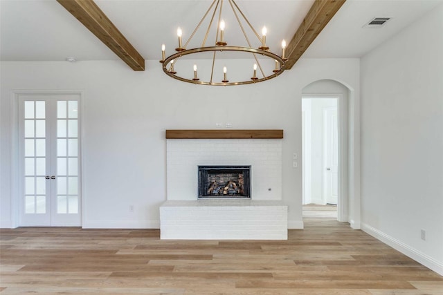 108 W Observation Dr, Aledo, TX 76008 - unfurnished living room with beamed ceiling, a chandelier, light wood-type flooring, a fireplace, and french doors