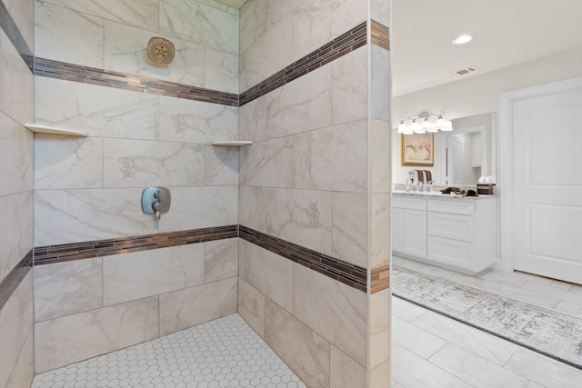 bathroom featuring tile patterned floors, vanity, and tiled shower