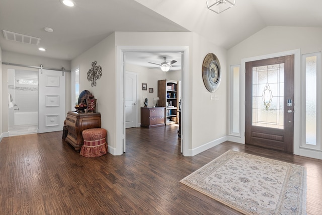 foyer featuring ceiling fan, a barn door, and dark wood-type flooring