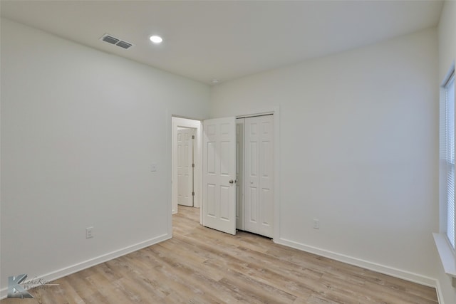 unfurnished bedroom featuring light hardwood / wood-style flooring and a closet