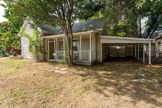 view of front of home featuring a carport, a front yard, and covered porch