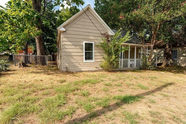 view of side of property featuring a porch and a yard