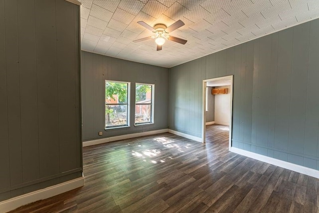 spare room with dark hardwood / wood-style floors, a wall mounted air conditioner, and ceiling fan