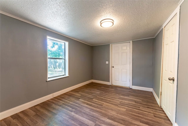 unfurnished bedroom featuring ornamental molding, dark wood-type flooring, a textured ceiling, and a closet