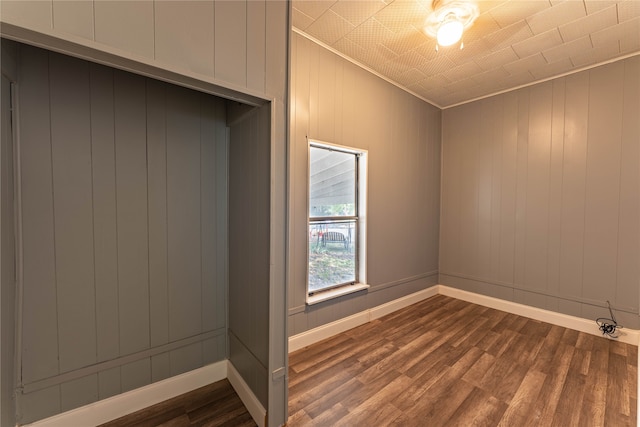 empty room featuring ornamental molding and hardwood / wood-style floors