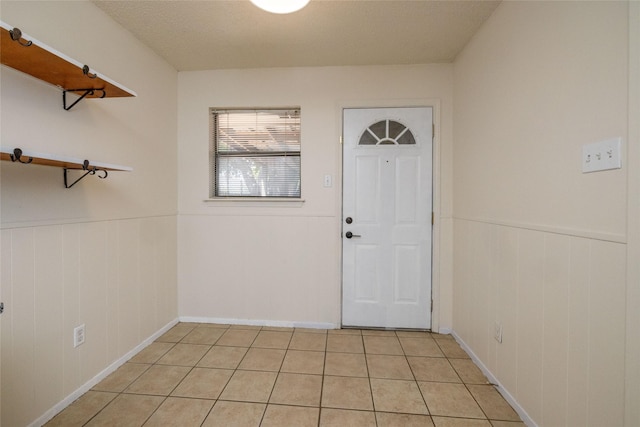 interior space featuring a wainscoted wall and light tile patterned floors