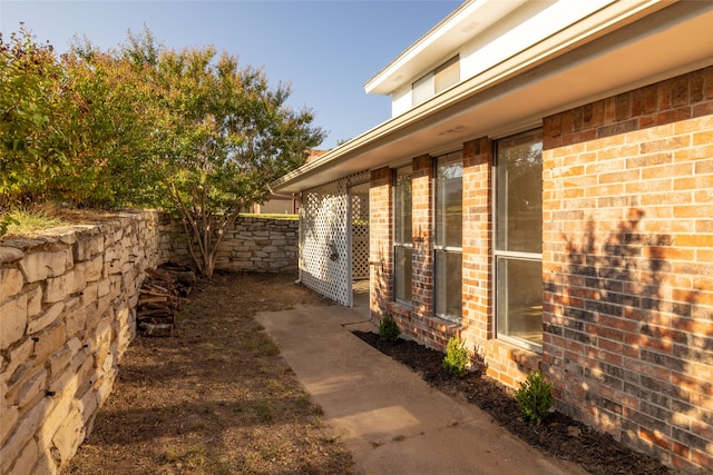 view of home's exterior featuring fence and brick siding