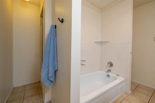 full bath featuring a garden tub, baseboards, and tile patterned floors