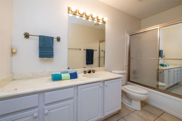 full bath featuring toilet, enclosed tub / shower combo, vanity, a textured ceiling, and tile patterned floors