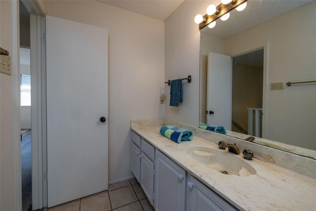 bathroom with tile patterned flooring, vanity, and a textured ceiling