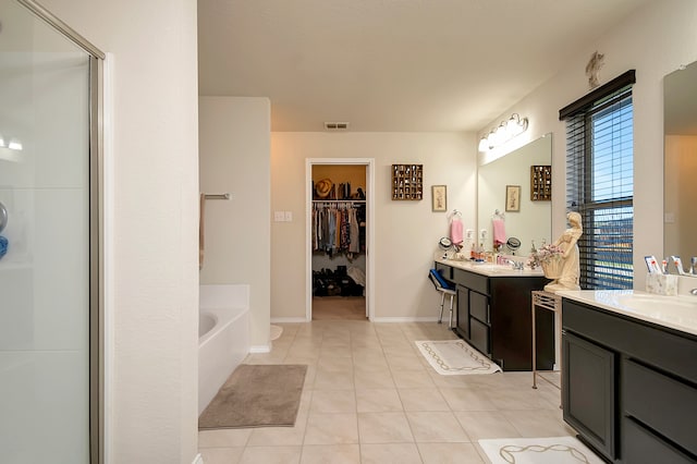 bathroom featuring tile patterned floors, vanity, and a tub to relax in