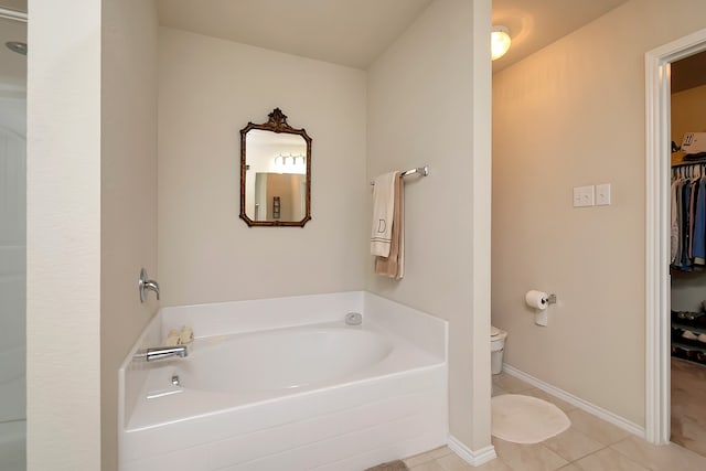 bathroom with a bathtub, toilet, and tile patterned flooring