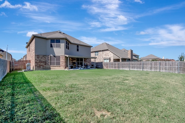 back of house featuring a patio area and a lawn