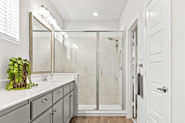 bathroom with wood-type flooring, vanity, and walk in shower