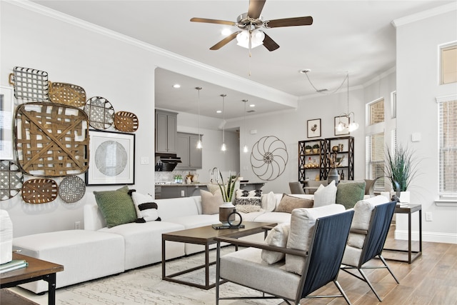 living room featuring light hardwood / wood-style flooring, crown molding, and ceiling fan