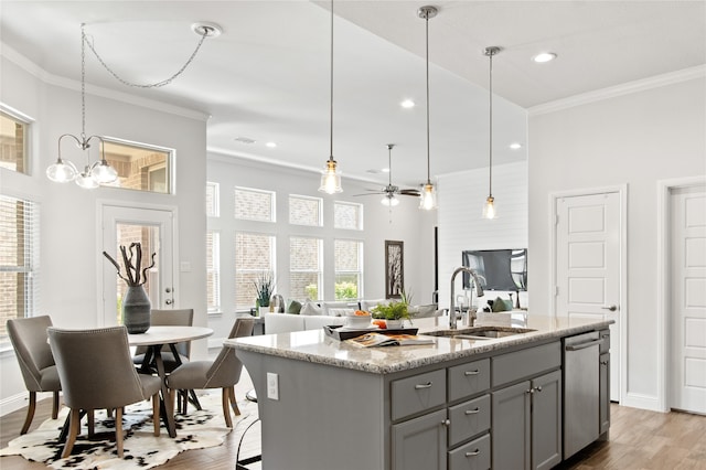 kitchen with hardwood / wood-style floors, sink, an island with sink, and stainless steel dishwasher