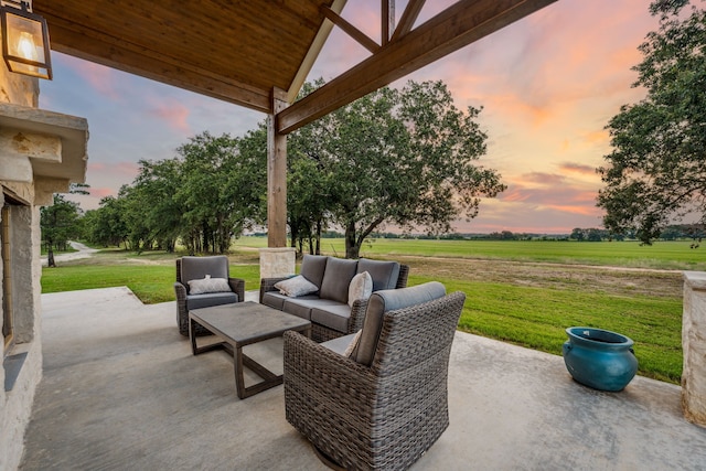 patio terrace at dusk featuring a lawn