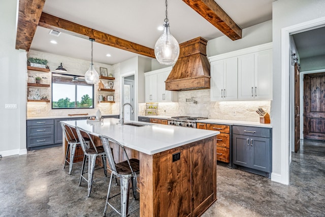 kitchen with beamed ceiling, decorative light fixtures, a kitchen bar, premium range hood, and white cabinetry