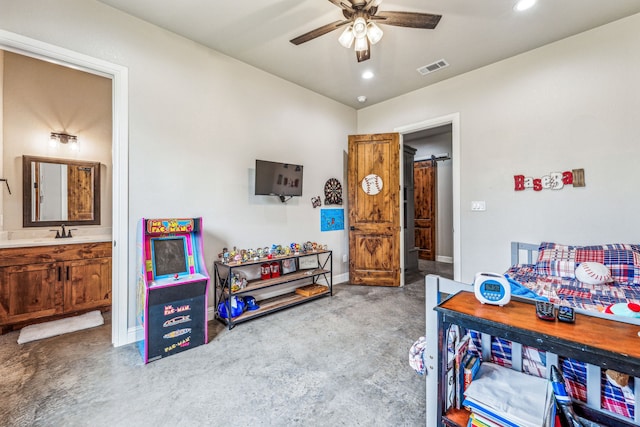 playroom featuring a barn door, concrete floors, sink, and ceiling fan