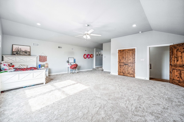 unfurnished bedroom with ceiling fan, vaulted ceiling, and light carpet