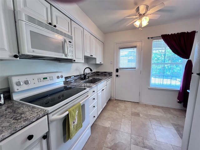 kitchen with sink, white cabinets, dark stone countertops, white appliances, and ceiling fan