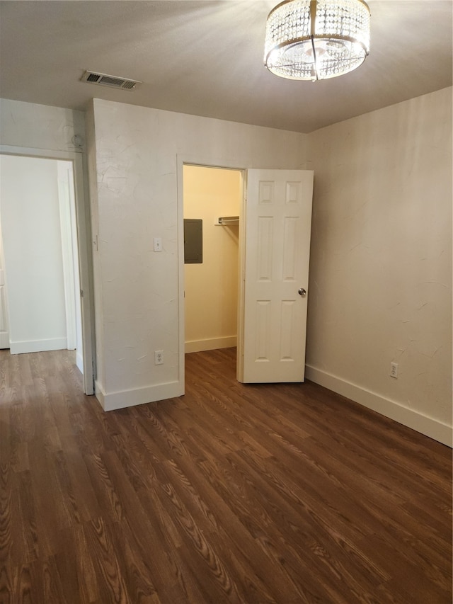 unfurnished bedroom featuring a closet, hardwood / wood-style flooring, and a walk in closet