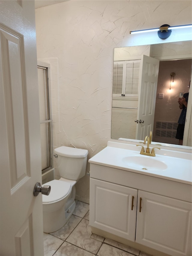 bathroom featuring vanity, tile patterned flooring, and toilet