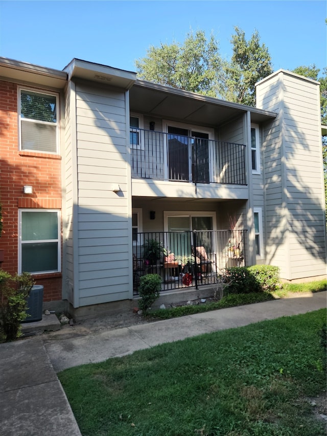 view of front of house featuring a balcony and a front yard