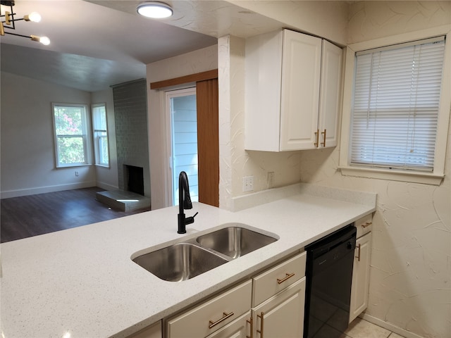 kitchen featuring dishwasher, sink, white cabinetry, light hardwood / wood-style floors, and light stone counters