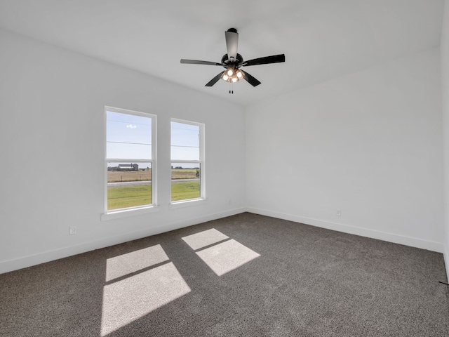 empty room with ceiling fan and dark colored carpet