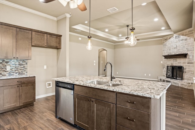 kitchen with a fireplace, sink, a raised ceiling, ceiling fan, and stainless steel dishwasher