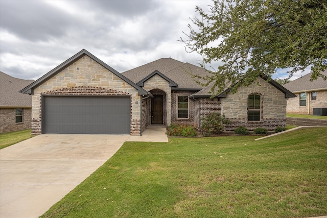 french country style house featuring central AC, a garage, and a front lawn