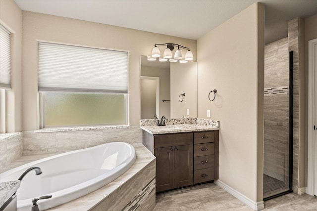 bathroom featuring a healthy amount of sunlight, separate shower and tub, and vanity