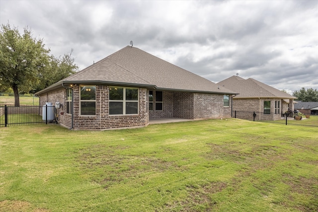 rear view of house with a yard and a patio area