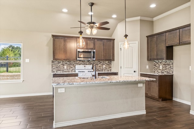 kitchen with dark wood-type flooring, ceiling fan, light stone counters, and an island with sink