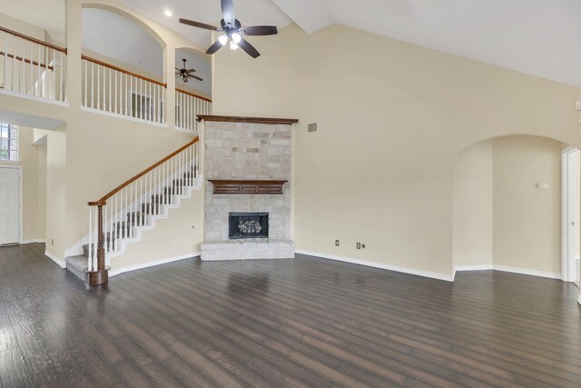 unfurnished living room featuring high vaulted ceiling, a fireplace, dark wood-type flooring, and ceiling fan