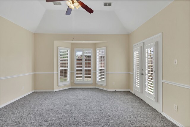 empty room featuring ceiling fan, vaulted ceiling, plenty of natural light, and carpet