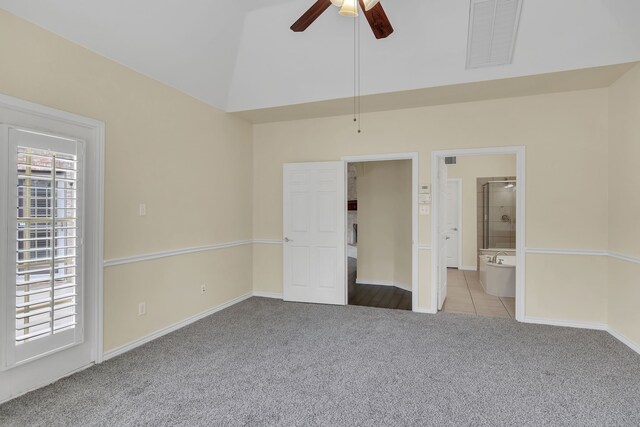 unfurnished bedroom featuring ensuite bathroom, light carpet, vaulted ceiling, and ceiling fan